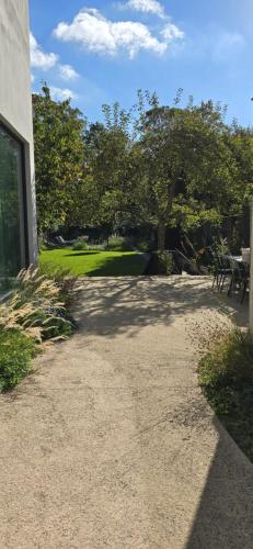 a walkway next to a building with a tree at B'Guest Sleep & Retreat in Bruges