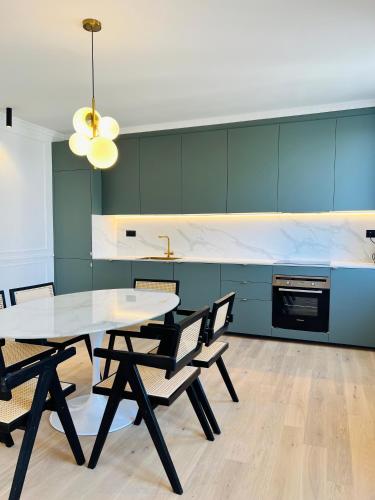 une salle à manger avec une table et des chaises blanches dans l'établissement Le Notre-Dame, mon appartement Cosy et Elegant, à Strasbourg