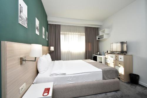 a hotel room with a bed and a desk at In City Hotel in Yerevan