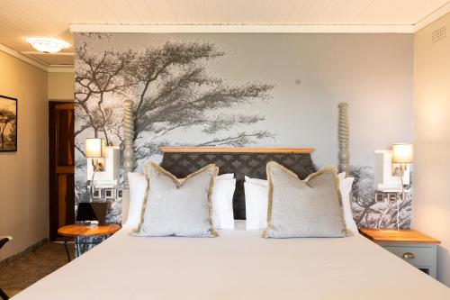 a bedroom with a large bed with white pillows at Rupurara Valley Lodge in Juliasdale