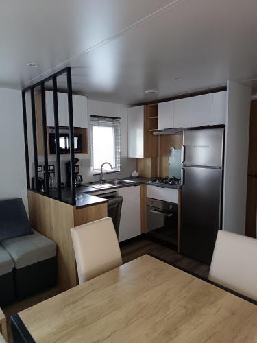 une petite cuisine avec une table et des chaises dans une pièce dans l'établissement MH F101 Camping Bois Masson, à Saint-Jean-de-Monts