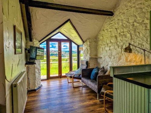 a living room with a couch and a stone wall at Clyne Farm Centre in The Mumbles