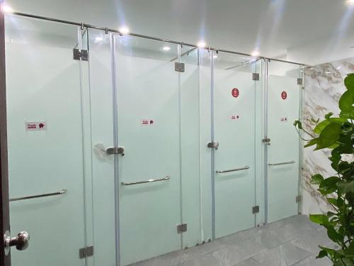 a row of four shower stalls in a bathroom at Quoc Cuong Hotel & Apartment Danang by Haviland in Da Nang