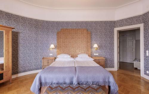 a bedroom with a large bed with blue walls at Hotel Esplanade, BW Signature Collection in Stockholm