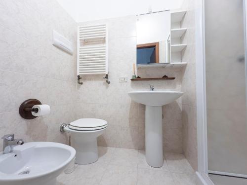 un bagno bianco con lavandino e WC di I Host Apartment - Orti 16 Scala D a Milano