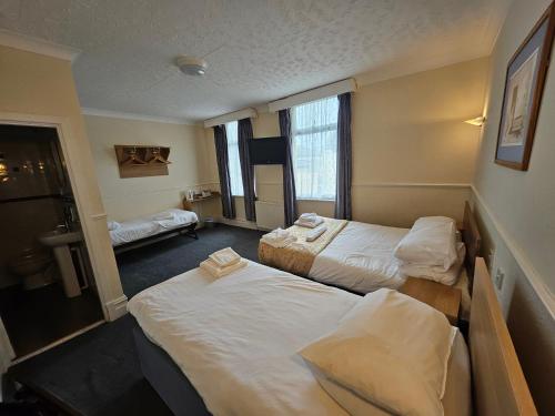 a hotel room with two beds and a bathroom at The President Hotel in Blackpool