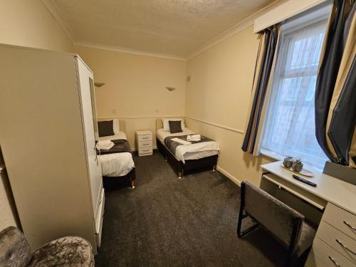 a hotel room with two beds and a window at The President Hotel in Blackpool