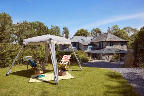 a gazebo with two chairs in a yard at Ty Pandy Eclectic Luxury Family cottage in Rowen Sleeps 10 in Conwy