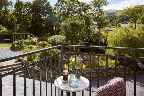 a table and two chairs on a balcony at Ty Pandy Eclectic Luxury Family cottage in Rowen Sleeps 10 in Conwy