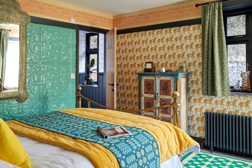 a bedroom with a bed with a purse on it at Ty Pandy Eclectic Luxury Family cottage in Rowen Sleeps 10 in Conwy