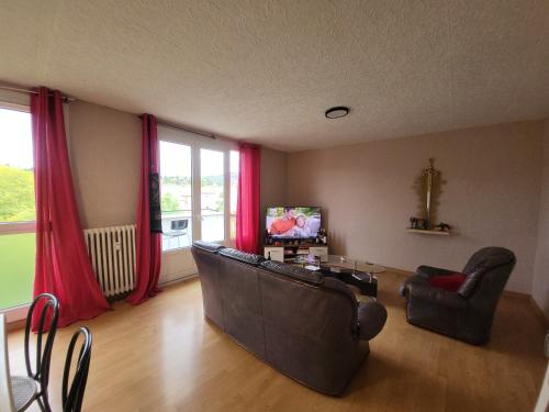 - un salon avec deux chaises, un canapé et une télévision dans l'établissement Chez Danna, à Millau