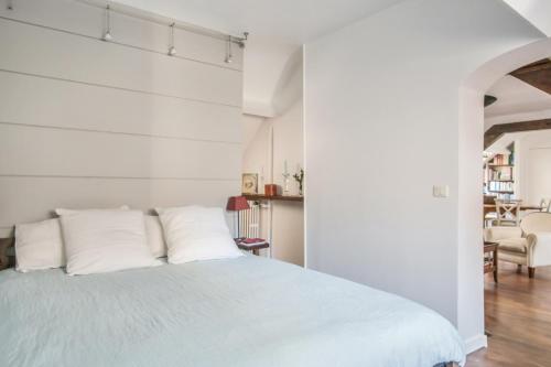 une chambre avec un lit blanc avec des oreillers blancs dans l'établissement Appartement Imperio - Welkeys, à Paris