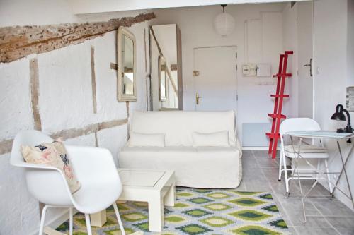 un salon avec des chaises blanches et une table dans l'établissement Studio Côte Blanche - Welkeys, à Nice