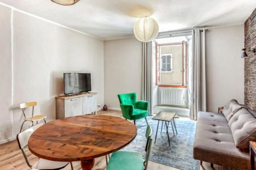 - un salon avec une table en bois et des chaises vertes dans l'établissement Appartement Sainte Claire Vintage - Welkeys, à Annecy