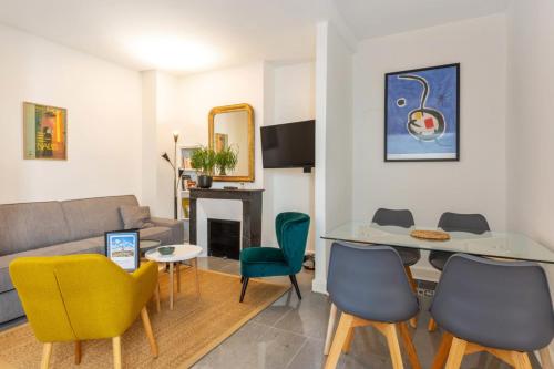 un salon avec un canapé, une table et des chaises dans l'établissement Appartement du Marché St Honoré - Welkeys, à Paris