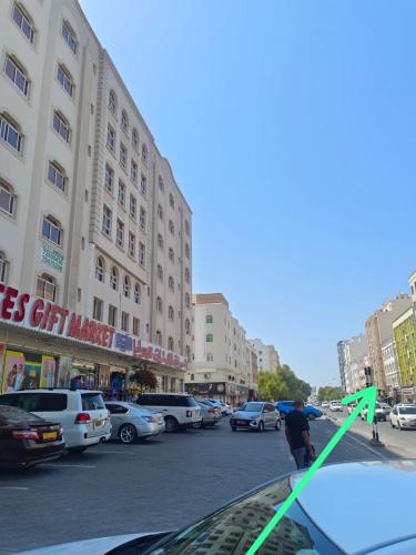 a man standing on the hood of a car in a parking lot at AL SHAMS MUSCAT MALE hostel in Muscat