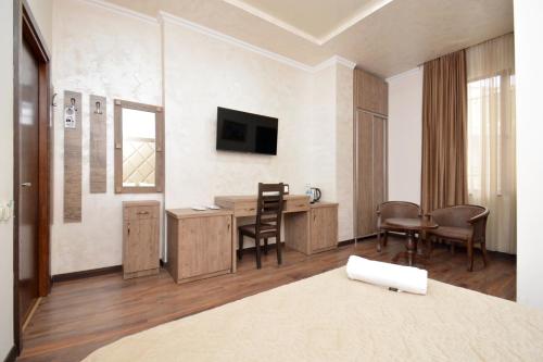 a hotel room with a desk and a television at Partez Hotel in Yerevan