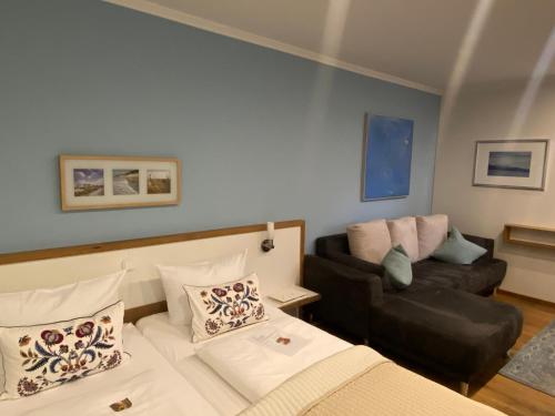 a living room with a bed and a couch at Boutique-garni Hotel Papillon in Kempen