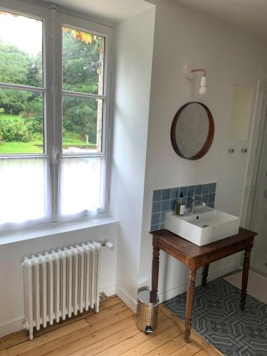 a bathroom with a sink and a mirror and a window at La Grimaudière in La Chapelle-sur-Erdre
