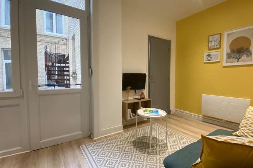 un salon avec un canapé et une télévision dans l'établissement Appart Hôtel Lille Beaux Arts - Mireille, à Lille