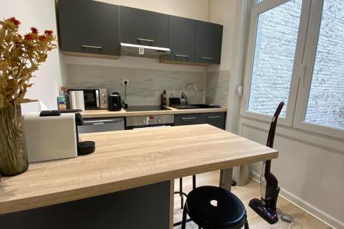 - une cuisine avec une table en bois et un comptoir dans l'établissement Appart Hôtel Lille Beaux Arts - Mireille, à Lille