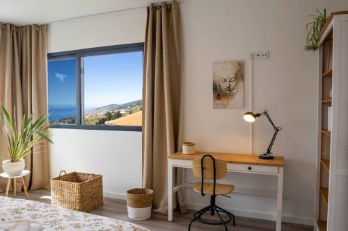 Schlafzimmer mit einem Schreibtisch und einem Fenster in der Unterkunft Vila Rouxinol in Arco da Calheta