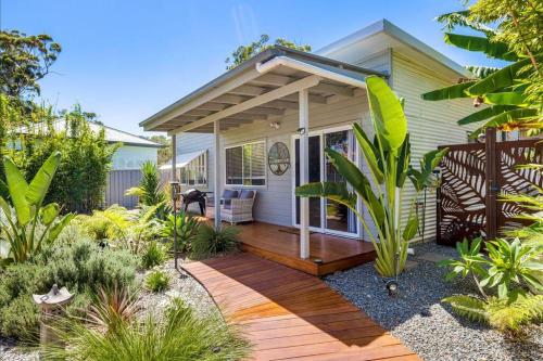 a house with a wooden deck in the yard at Shoaly House Cottage - A charming coastal escape in Shoal Bay