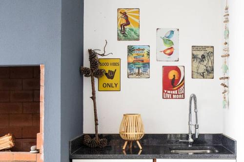 eine Küche mit einem Waschbecken und Plakaten an der Wand in der Unterkunft Vila Rouxinol in Arco da Calheta