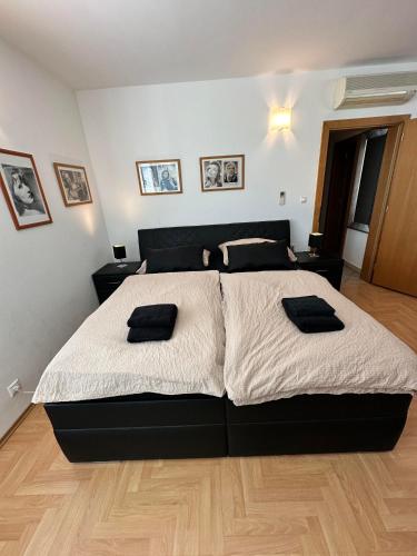 a bedroom with a large bed with black and white sheets at Hotel Muza in Košice