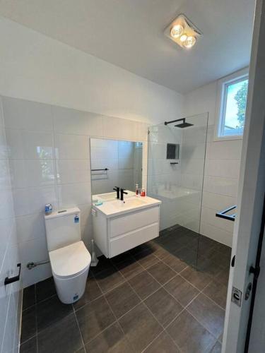 a bathroom with a toilet and a sink and a shower at Shoaly House Cottage - A charming coastal escape in Shoal Bay