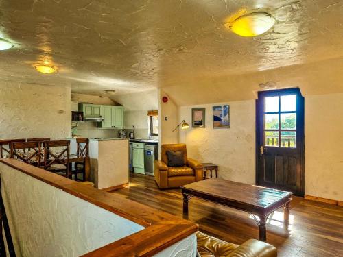 a living room with a table and a kitchen at Clyne Farm Centre in The Mumbles