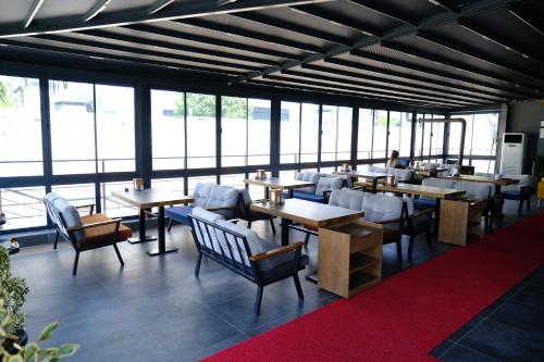 een restaurant met tafels, stoelen en ramen bij Side Mira Palace & Spa in Side
