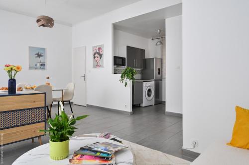 un salon avec une table et une cuisine dans l'établissement À 2 Pas de la plage des catalans, à Marseille