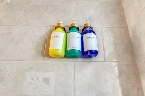 two shampoo bottles sitting on a tile floor at Crested One Place in Manchester