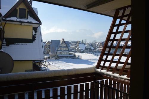 a balcony with a view of a snow covered yard at MSC Apartments Zaciszny in Zakopane