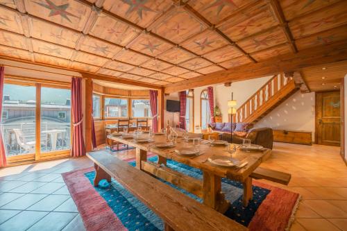 - une salle à manger avec une grande table et un canapé dans l'établissement Résidence Le Cristal - Mont Blanc 13 - Happy Rentals, à Chamonix-Mont-Blanc