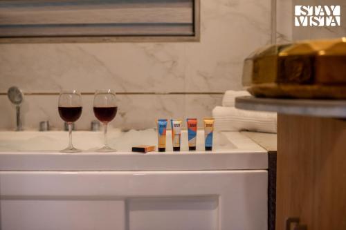 two glasses of wine sitting on top of a counter at Crystalline by VEO - Part of StayVista with Kids Room in Alibaug