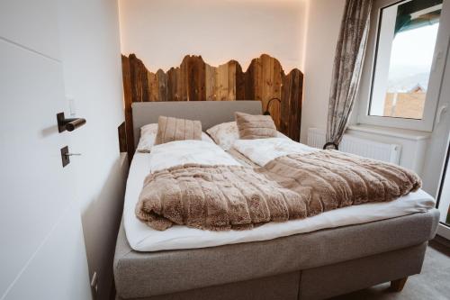 a bedroom with a bed with a wooden headboard at Panorama Lodge Edelweiss in Gosau