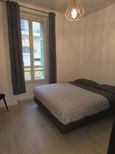 une chambre avec un lit et une fenêtre dans l'établissement Appartement cosy moderne calme hyper centre gare sncf, à Nice