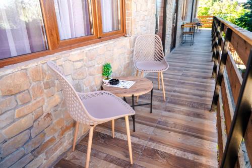 two chairs and a table on the porch of a building at Maksimilijan Winery Apartments & wine tasting in Pepelište