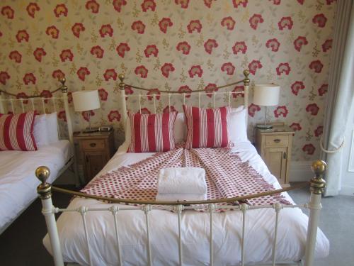 a bedroom with a bed with red and white pillows at Yeo Dale Hotel in Barnstaple