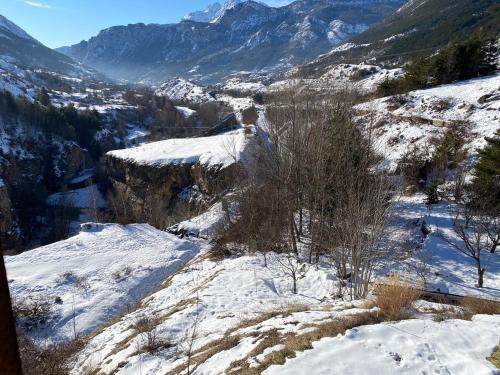 a snowy mountain with trees and mountains in the background at Chalet à un endroit exceptionnel, Alpes, Parc National des Ecrins in Les Vigneaux