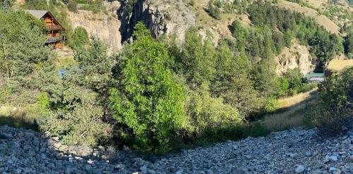 a house on the side of a mountain next to a river at Chalet à un endroit exceptionnel, Alpes, Parc National des Ecrins in Les Vigneaux