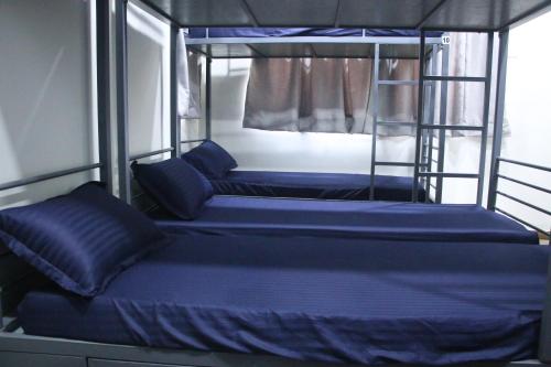 two bunk beds on a boat with blue sheets at Fostel- The Fort Hostel in Mumbai