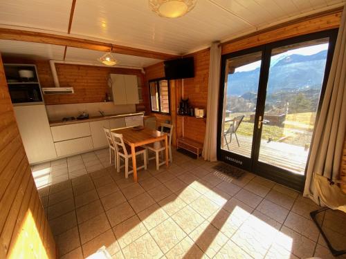 a kitchen with a table and a view of a mountain at Chalet à un endroit exceptionnel, Alpes, Parc National des Ecrins in Les Vigneaux