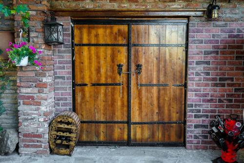 a wooden door on a brick building with flowers at Maksimilijan Winery Apartments & wine tasting in Pepelište