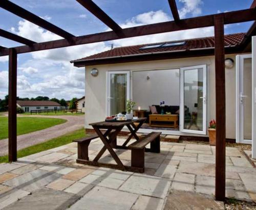 a patio with a picnic table in front of a house at Lovely 2 Bedroom Holiday Chalet near Sidmouth in Sidmouth