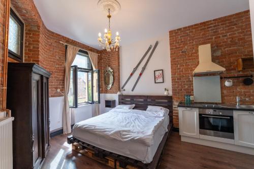 a bedroom with a bed and a brick wall at Barrique Studio in Braşov