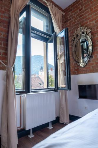 a bedroom with a window with a view of the ocean at Barrique 14 - Breakfast at Restaurant & Minibar - Old Town in Braşov