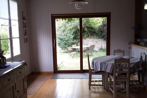 une cuisine avec une table et une porte coulissante en verre. dans l'établissement Charmante maison à 3 minutes à pied d'une plage magnifique, à Erquy